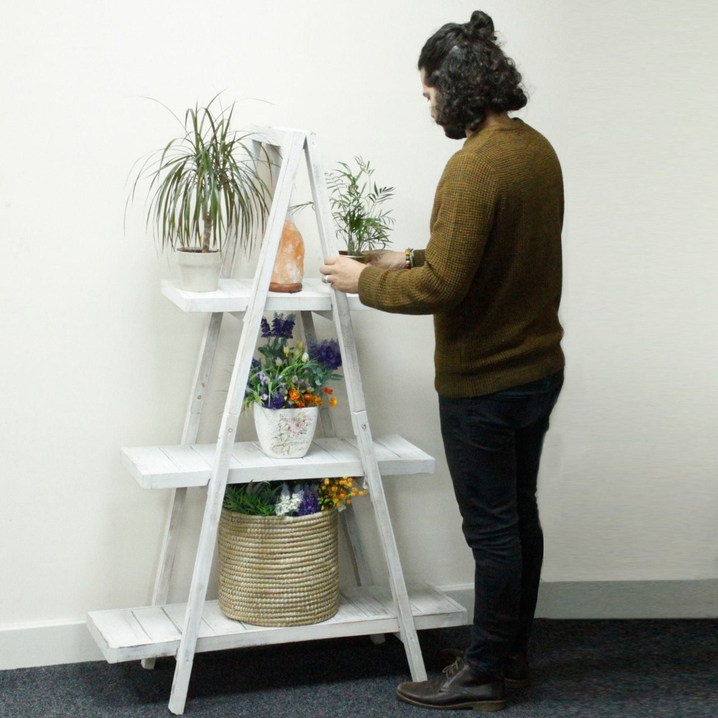 Alt Tag: Albasia Wood A-Frame Display – Vitkalkad med hyllor i flera nivåer som rymmer växter och inredningsdetaljer i en butiksliknande miljö
