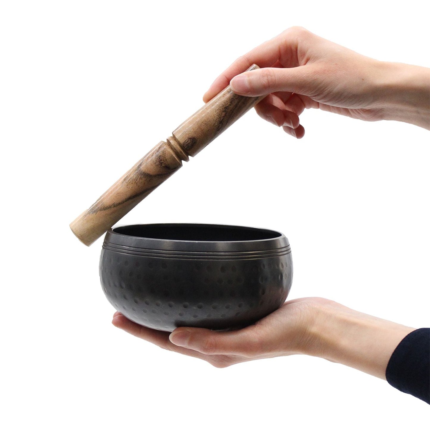 Black Brass Tibetan Singing Bowl – 14CM con mazo de madera, cuenco de latón negro sostenido en manos, vista de producto