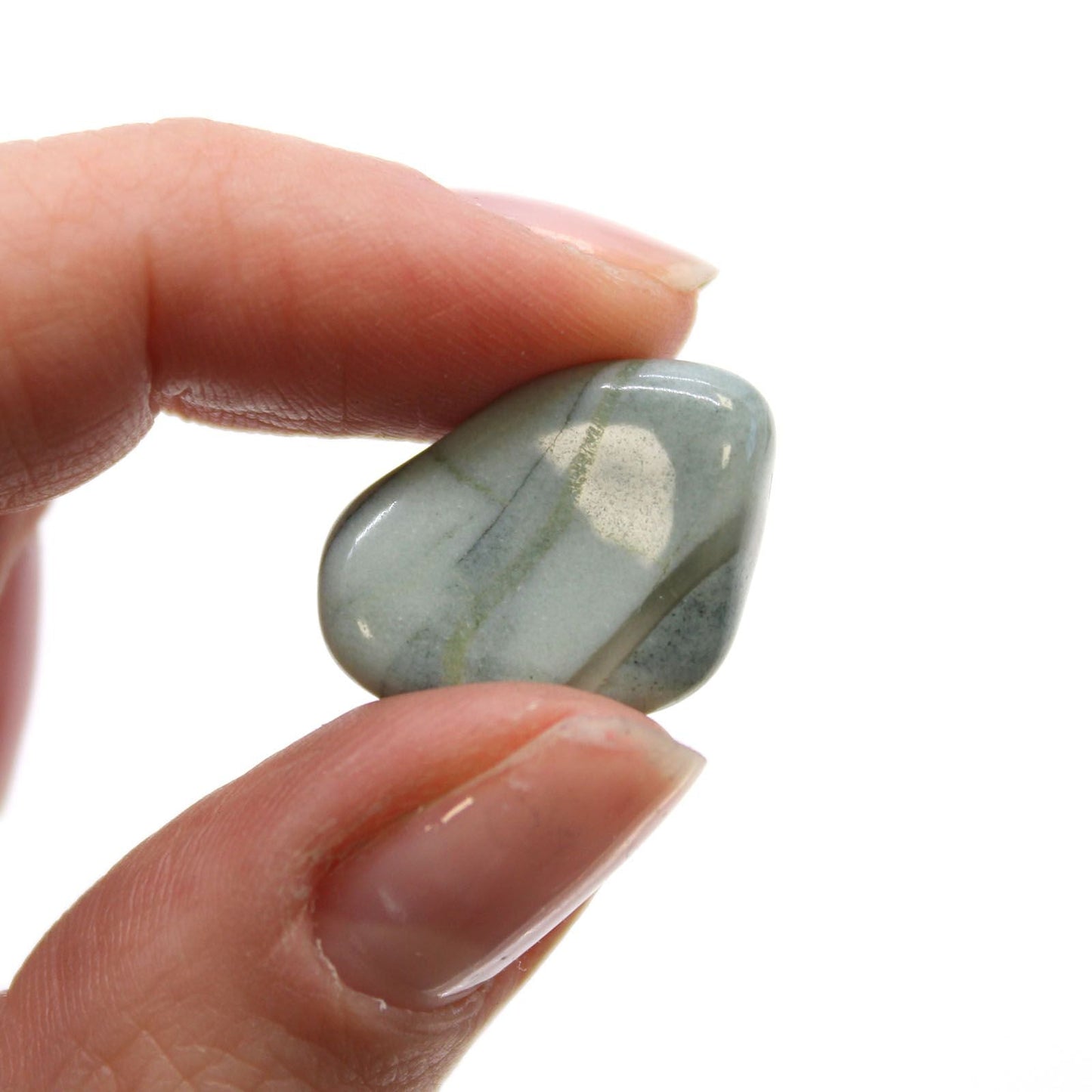 Gemstone Tumble Stones – Bloodstone Sephtonite pulido, piedra rodada gris verdosa sostenida entre los dedos, primer plano