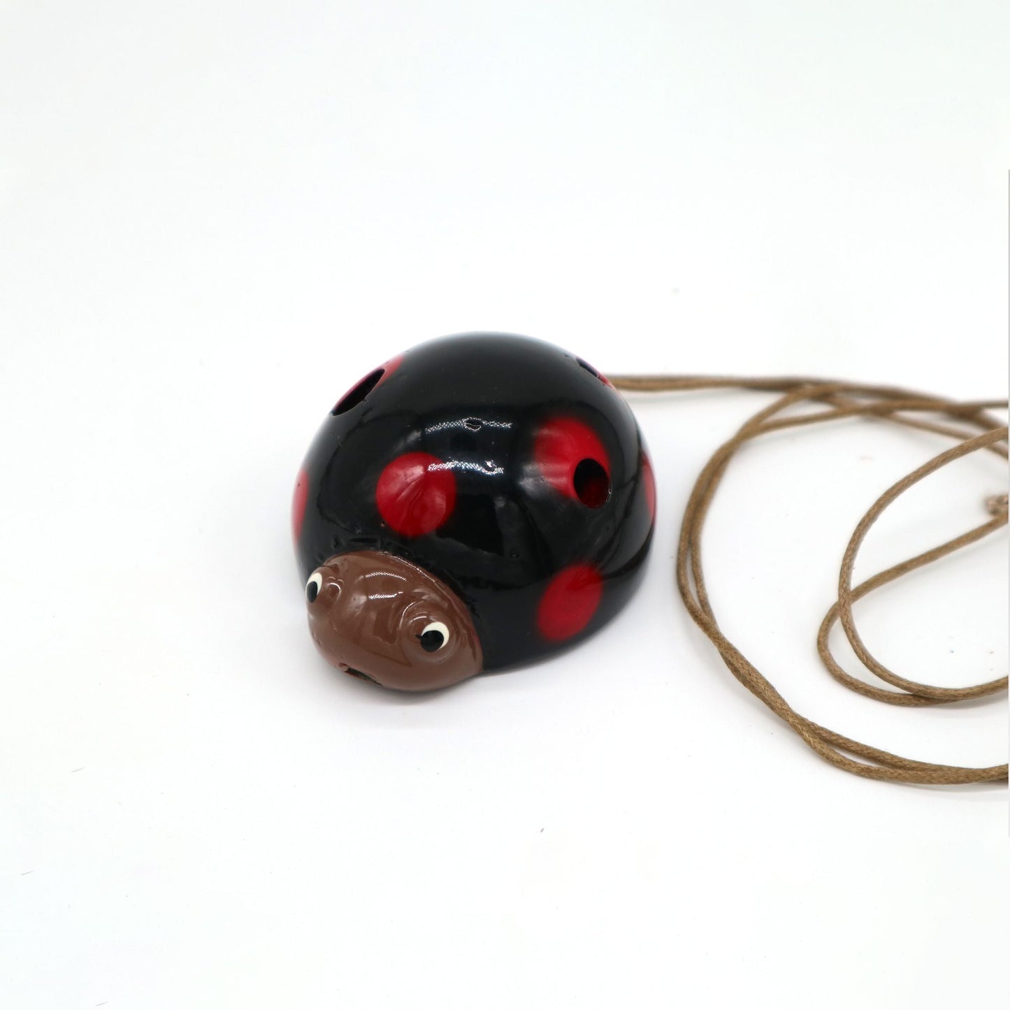Ceramic Ocarina – Ladybird Design, glazed ceramic ladybird-shaped ocarina with red spots and neck cord on white background