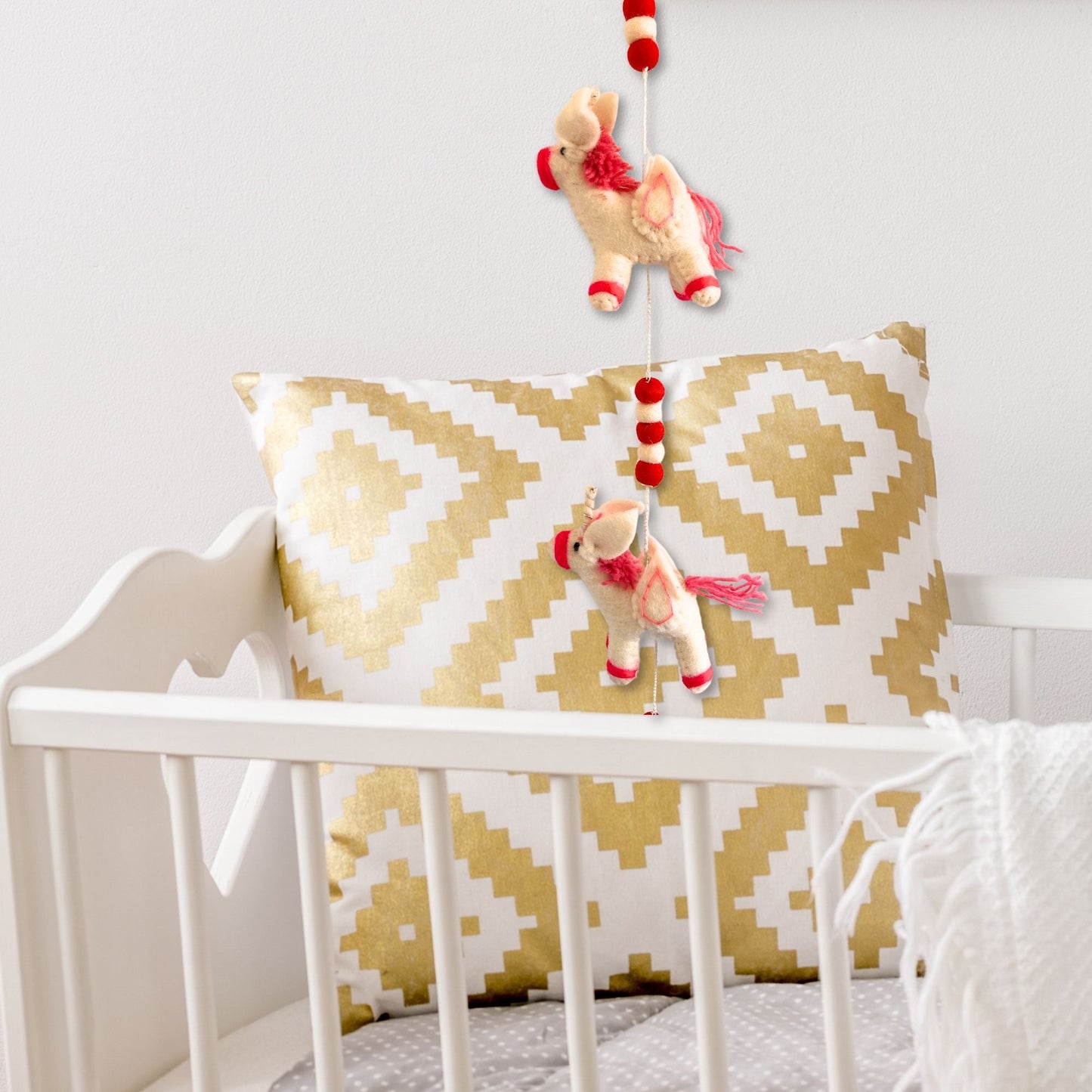 Alt Tag: Colorful Felt Unicorn Wall Hanging – 110CM hanging decor with colorful felt unicorns and pom-poms in nursery crib setting