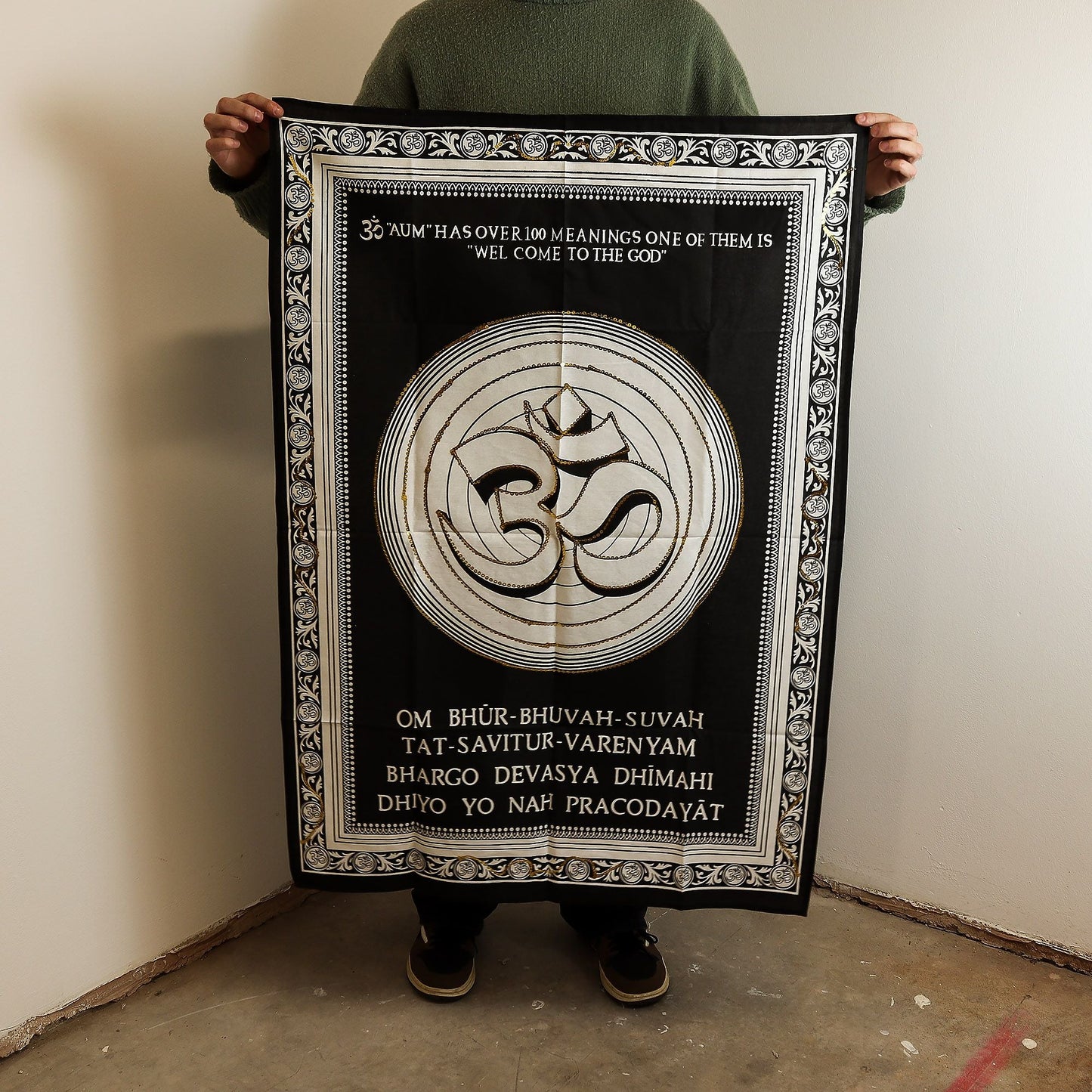Alt Tag: Cotton Om Wall Art – 70x110 CM black cotton wall hanging with Om symbol and decorative border, shown held up for size