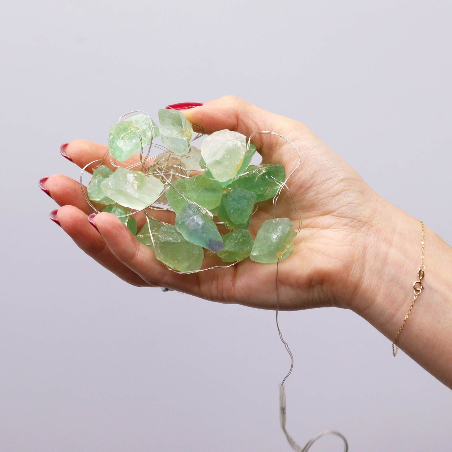 Alt Tag: Crystal Jade Gemstone Enchantment Lights – Decorative String held in hand with natural green jade stones on warm string lights