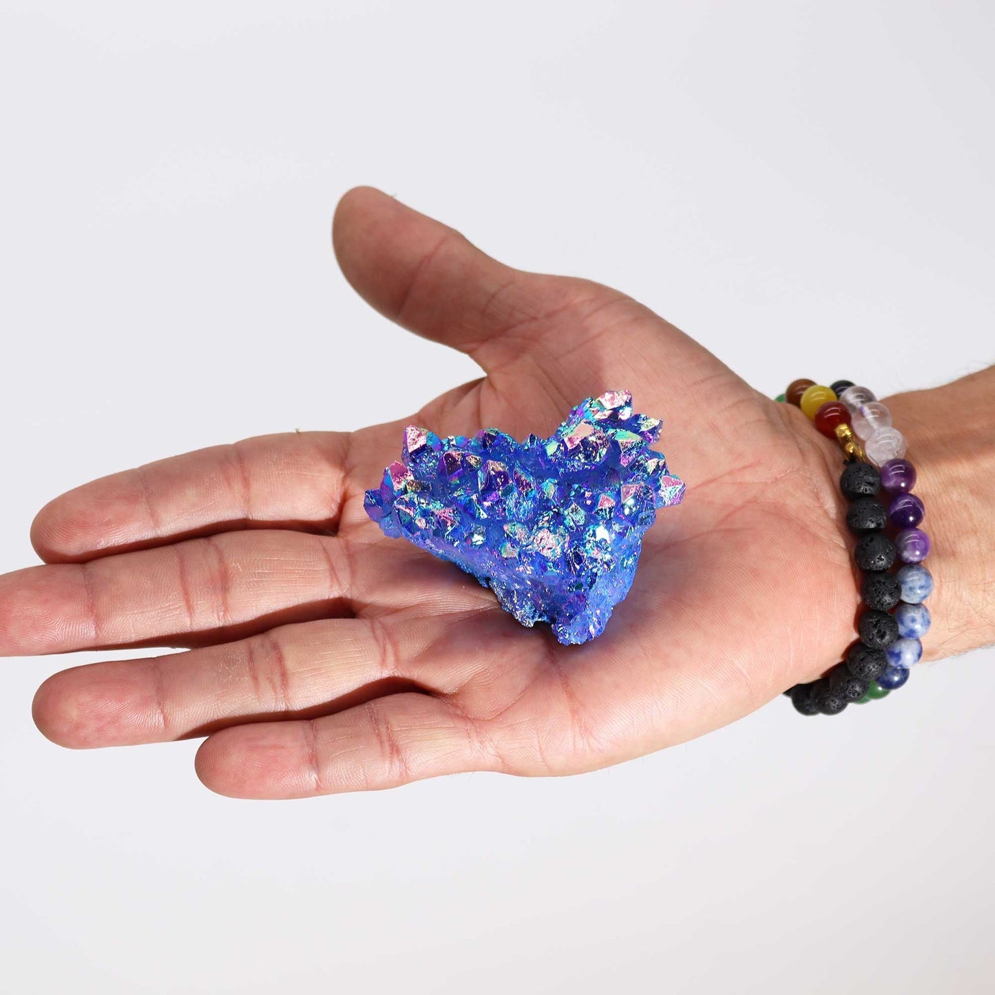 Alt Tag: Enhanced Quartz Geode – 100-150G 7-10CM azul iridiscente en la palma de una mano, cristal decorativo brillante