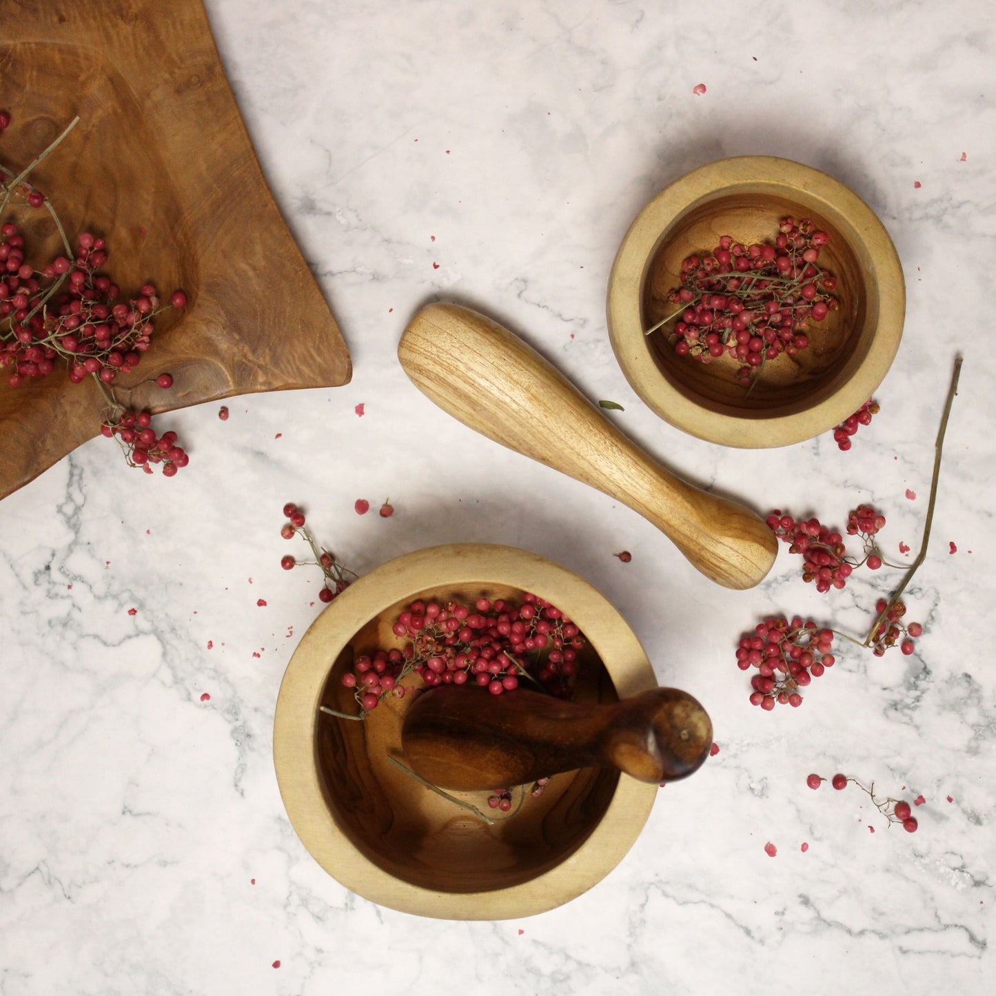 Ergo Teak Pestle & Mortar – Medium de madera de teca con mano ergonómica, mortero con granos de pimienta rosa sobre encimera