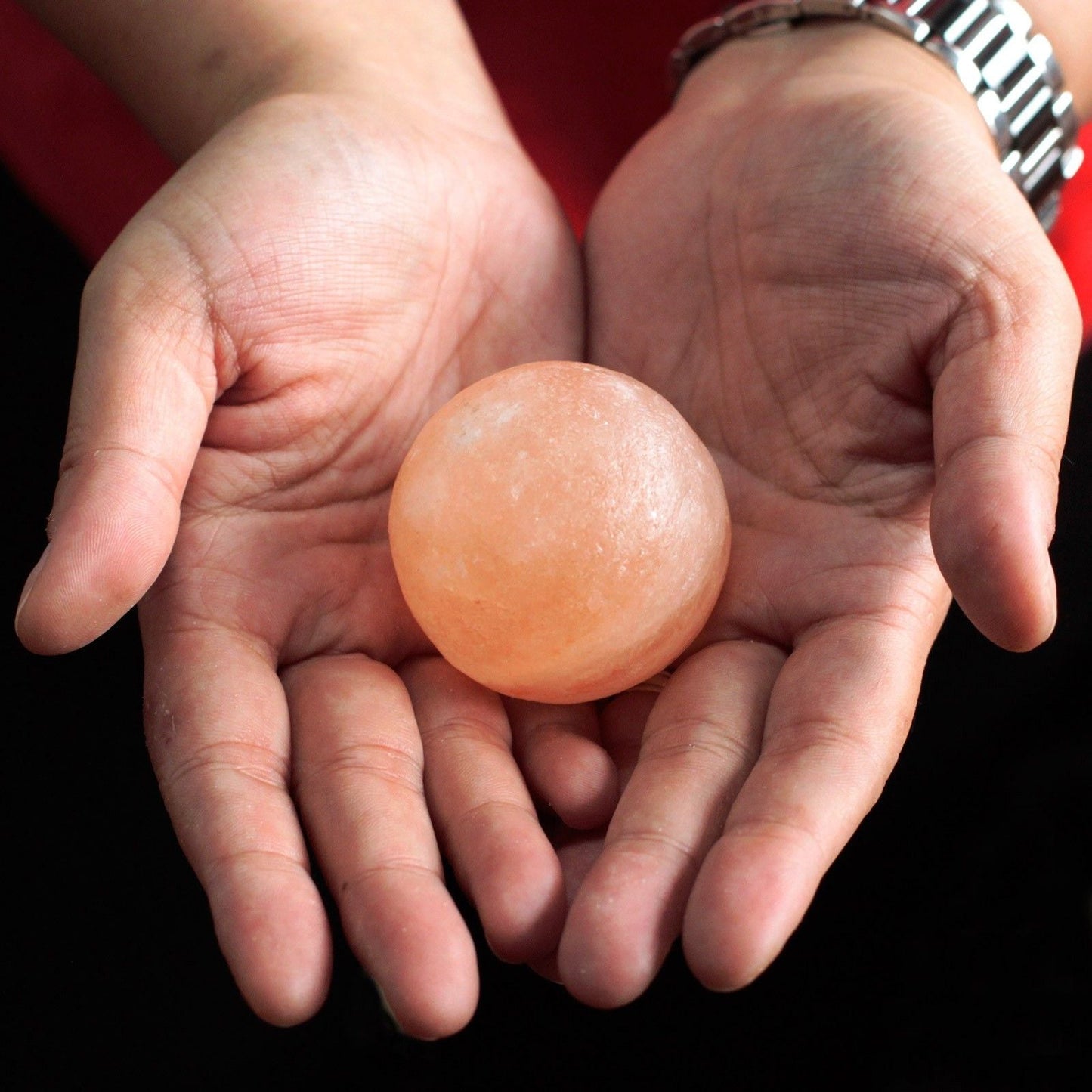 Alt Tag: Himalayan Salt Deodorant Stone – 4.5 CM Ball sostenida en manos, bola de sal del Himalaya tallada a mano para uso como desodorante natural