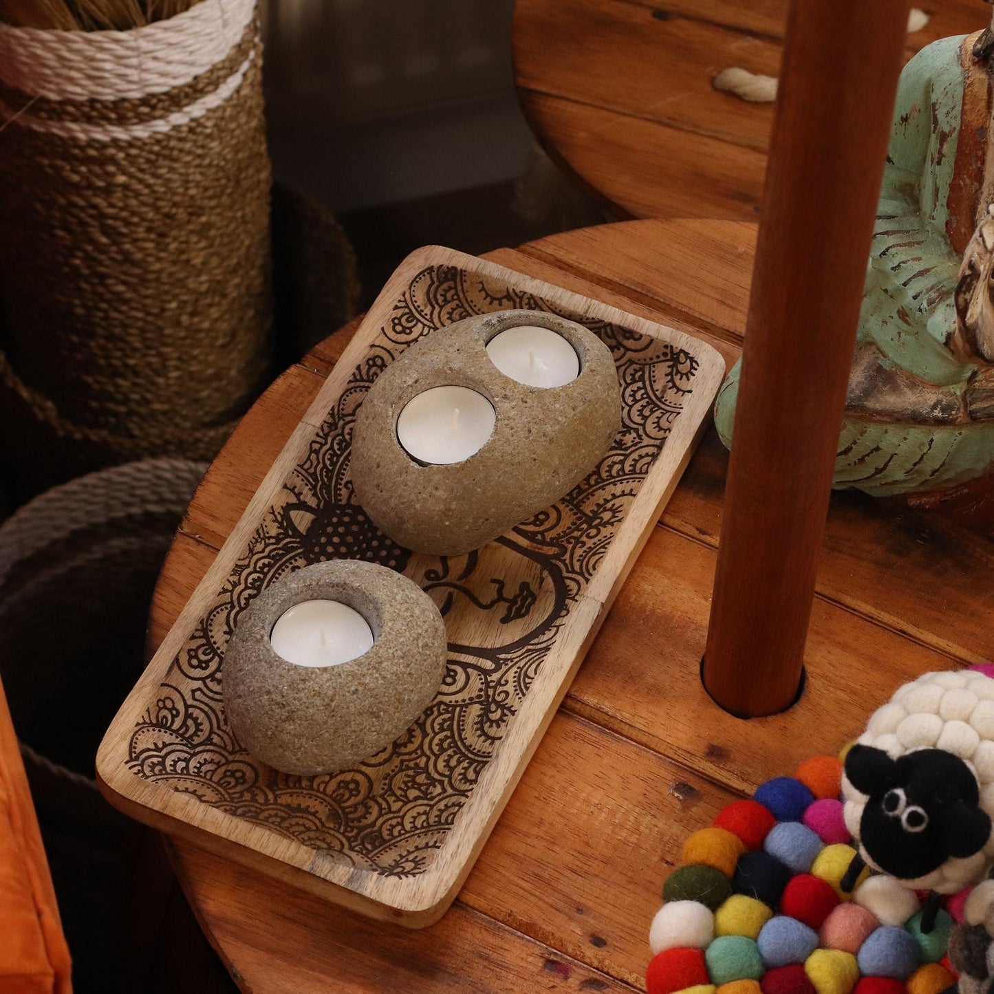 Riverstone Candle Holder – Single Tealight Charm aus indonesischem Flussstein mit Teelichtern, auf einem dekorativen Holztablett