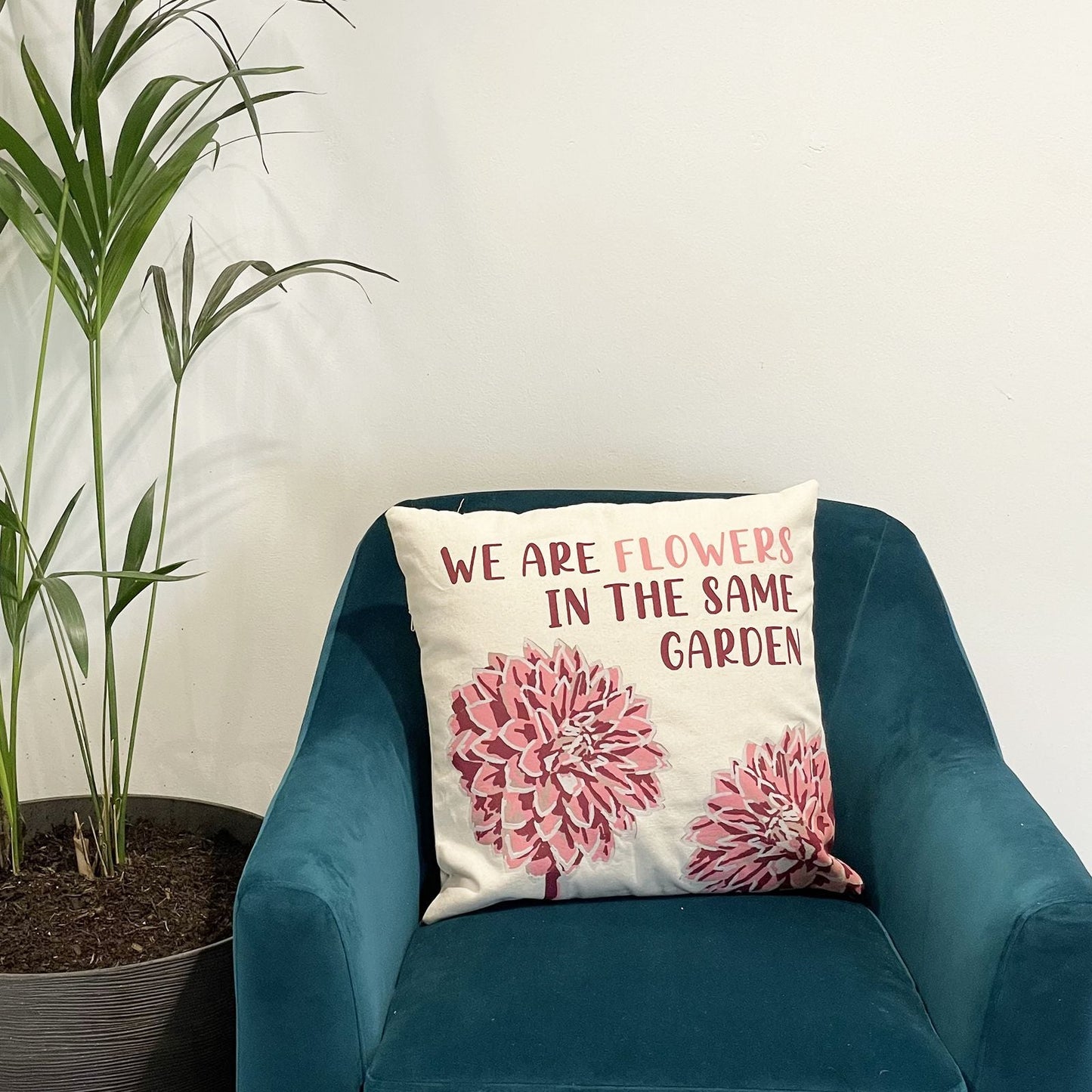 Alt Tag: Funda de cojín de algodón natural – 45x45 CM con estampado “We Are Flowers” en sillón verde azulado, diseño floral en algodón 100%