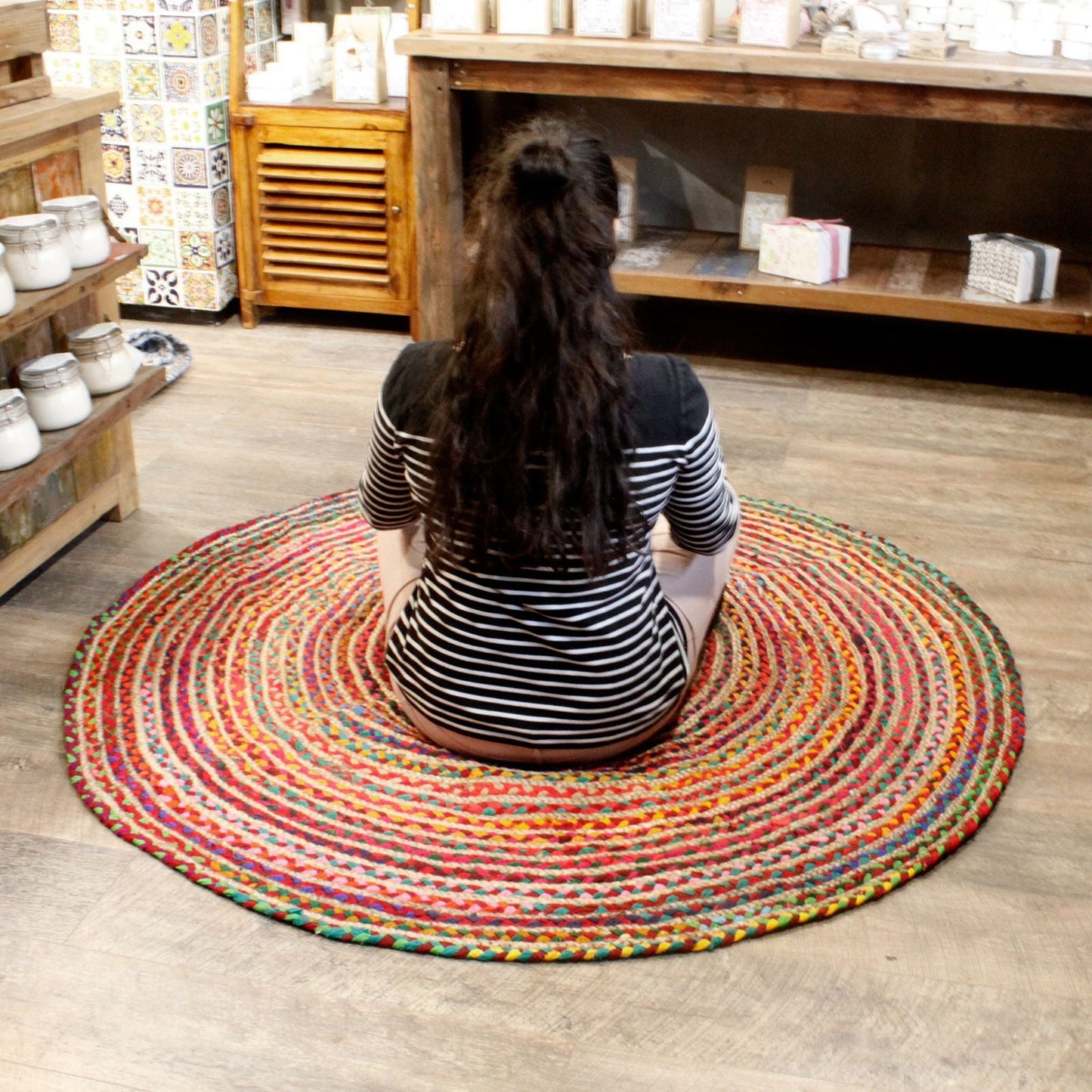 Round Jute and Recycled Cotton Rug – 150 CM redondo tejido a mano, multicolor, en sala de estar con persona sentada