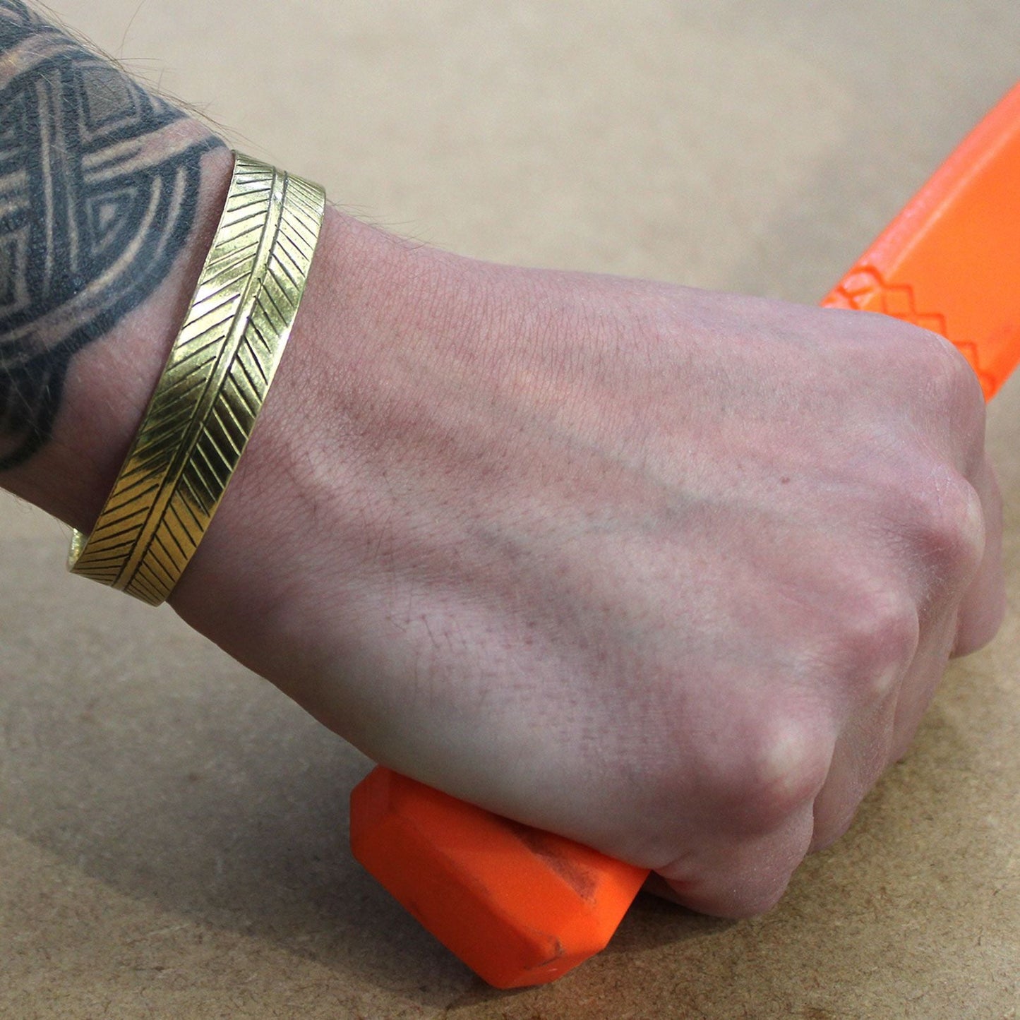 Alt Tag: Solid Brass Tibetan Bracelet – Wide Tribal Leaf on wrist, wide brass cuff with engraved tribal leaf pattern