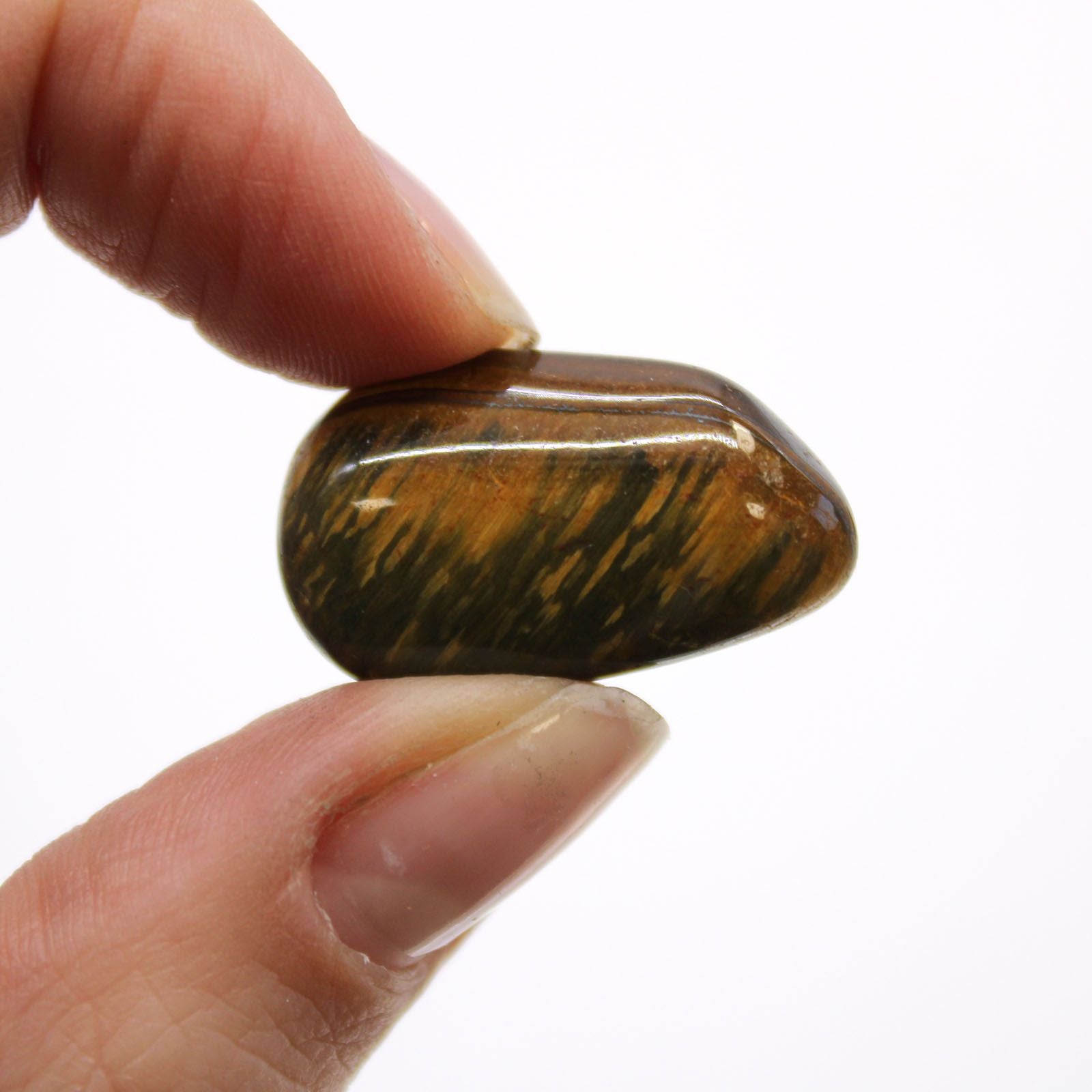 Alt Tag: Gemstone Tumble Stones – 24 Variegated Tiger’s Eye, close-up of polished Tiger’s Eye tumble stone held between fingers