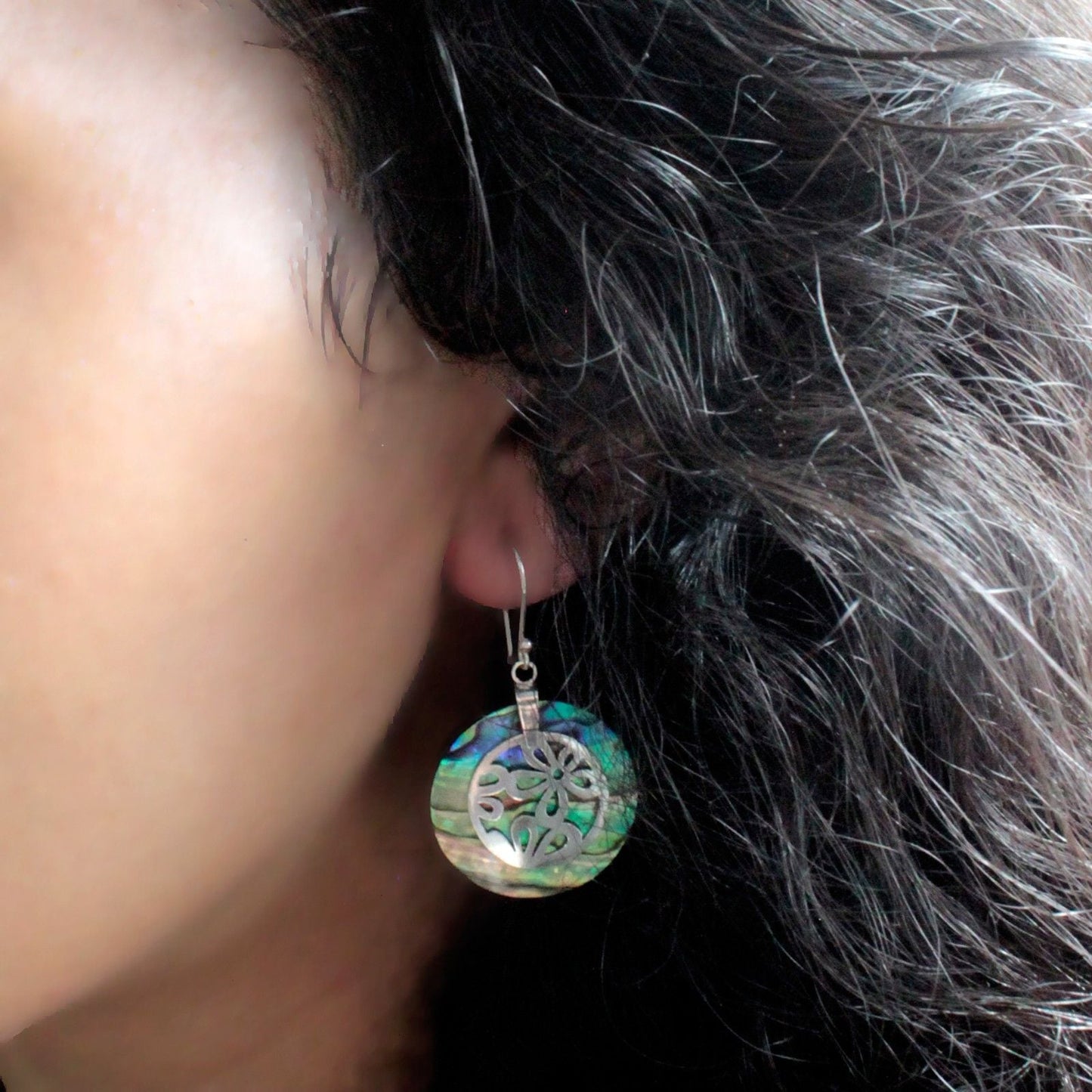 Alt Tag: Abalone Shell & Silver Earrings – Flower Design worn on ear, round abalone shell disc with floral 925 sterling silver overlay