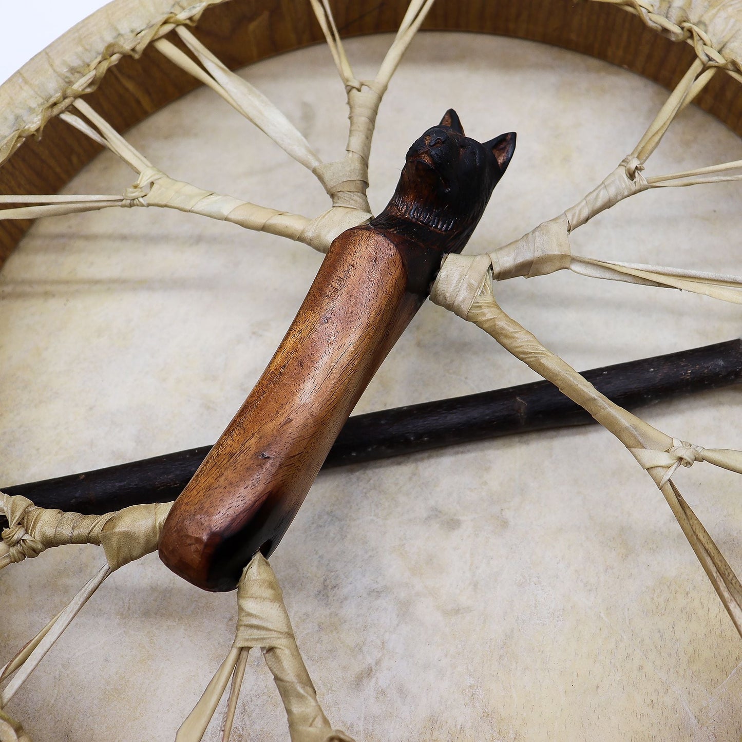 Akaciaträ shamantrumma – stämbar 40 cm getskinnstrumma med handskuret handtag med varghuvud och snörningsdetalj