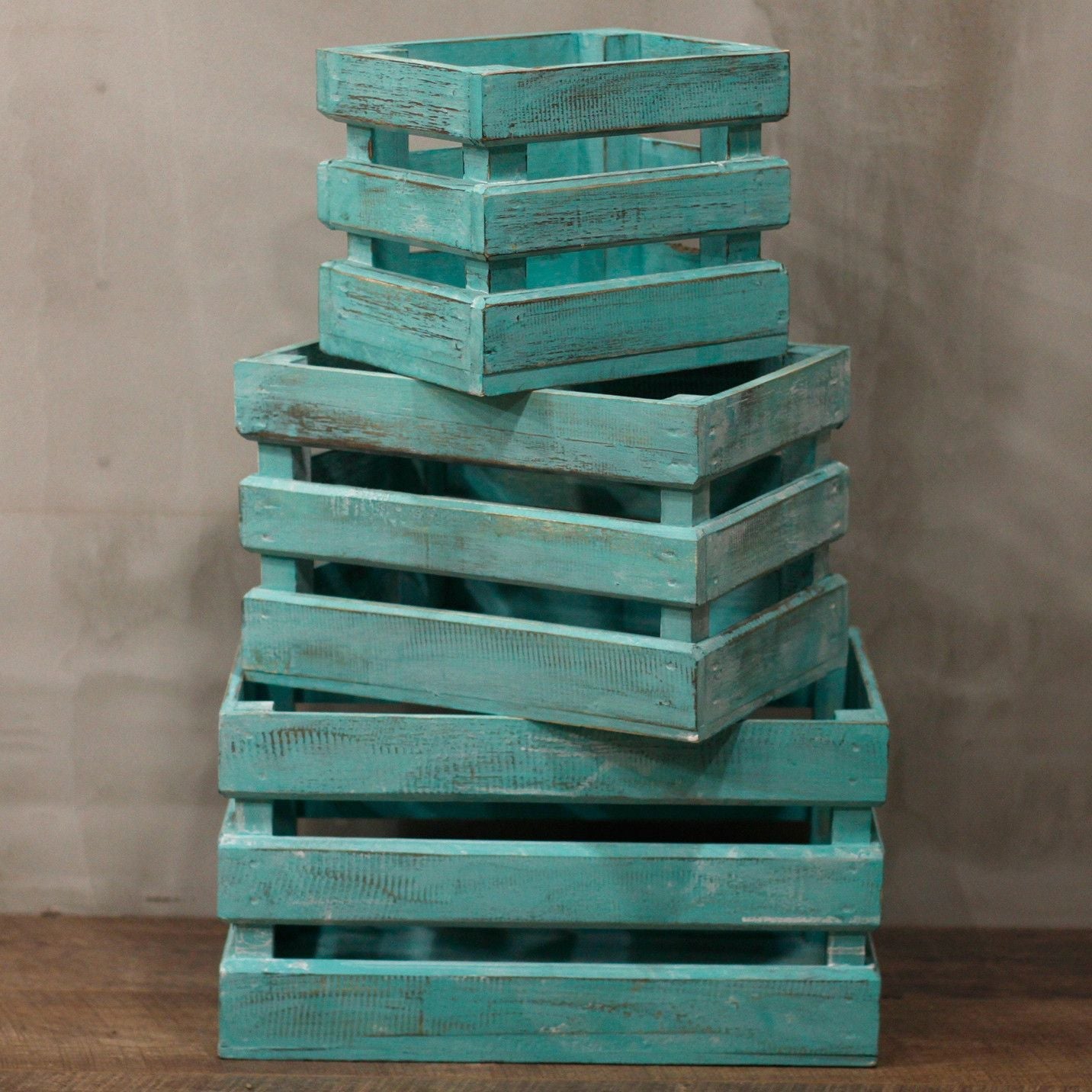 Cajas expositoras de madera de albasia – Set de 3 cajas expositoras de madera turquesa apiladas sobre una mesa