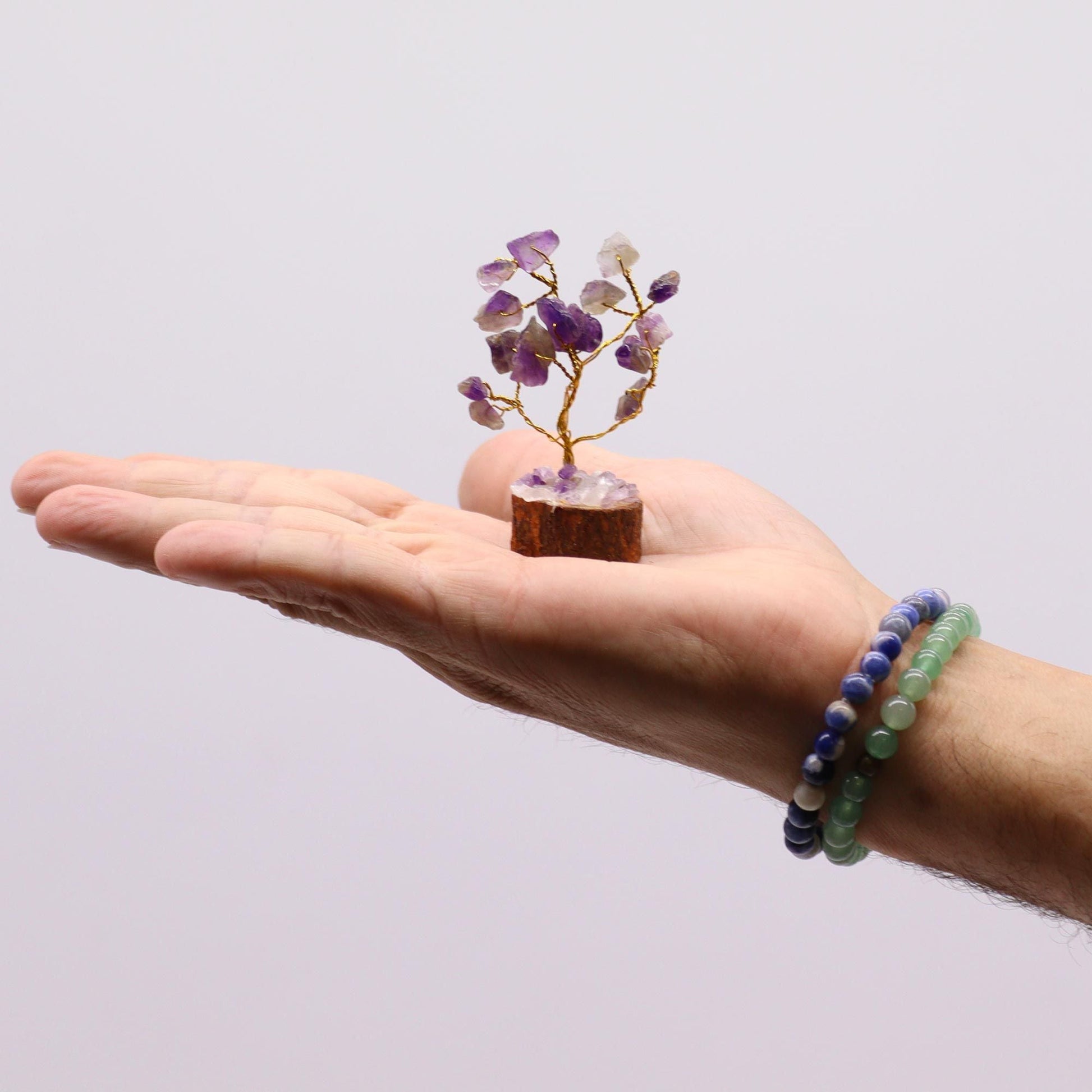 Alt Tag: Amethyst Gemstone Tree – 15 Stones, 6CM mini crystal tree with wood base held in hand, purple amethyst stones