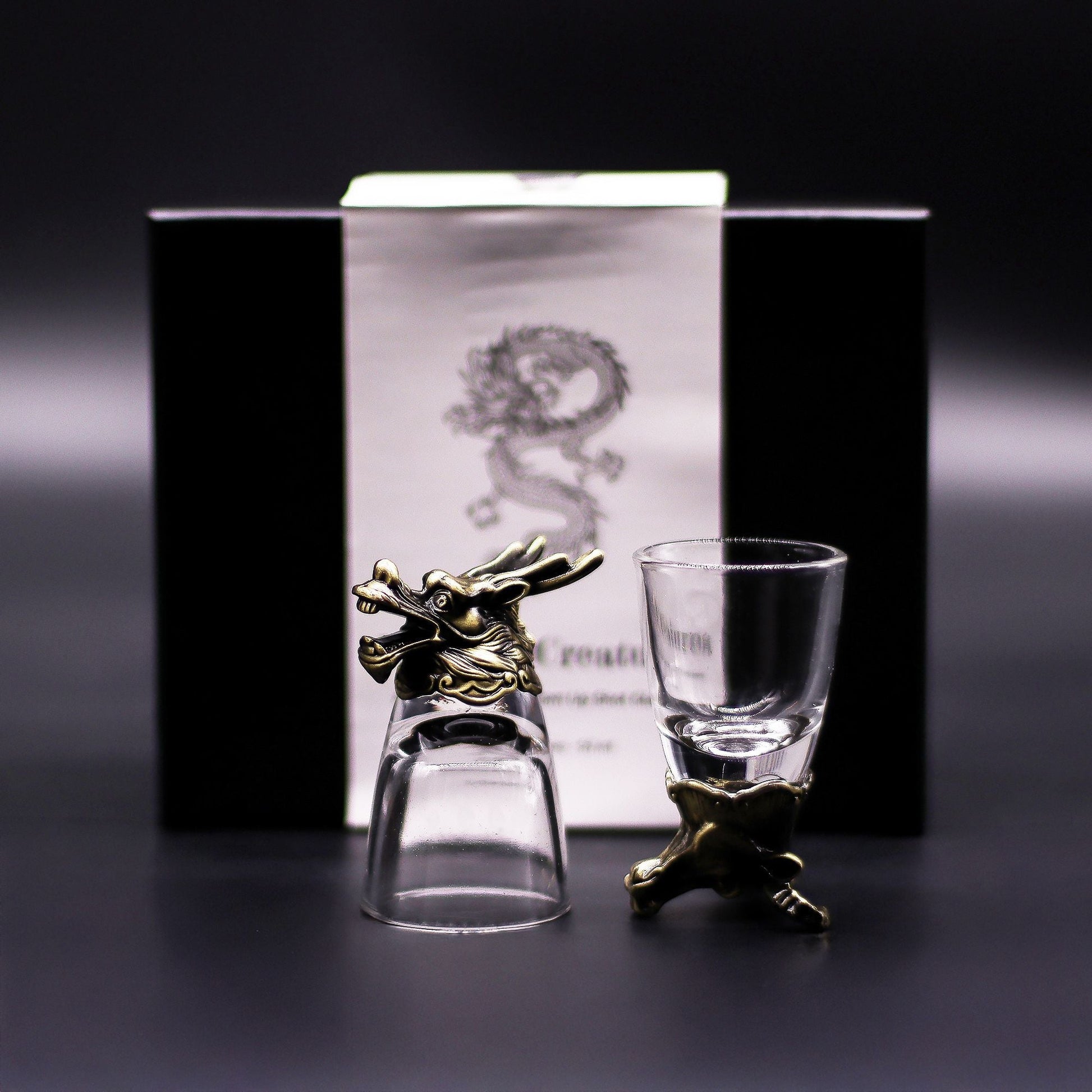 Alt Tag: Antique Bronze Mystical Creatures Glasses – 50 ML set, clear shot glasses with antique bronze creature stand, product box background