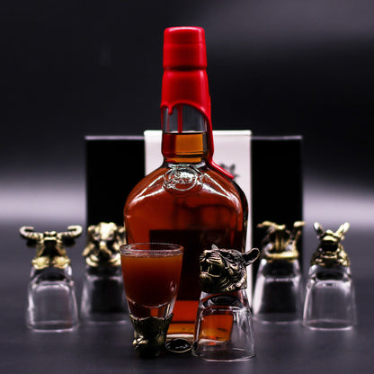 Antique Bronze Mystical Creatures Glasses – 50 ML set with bronze animal head shot glass beside liquor bottle on dark background