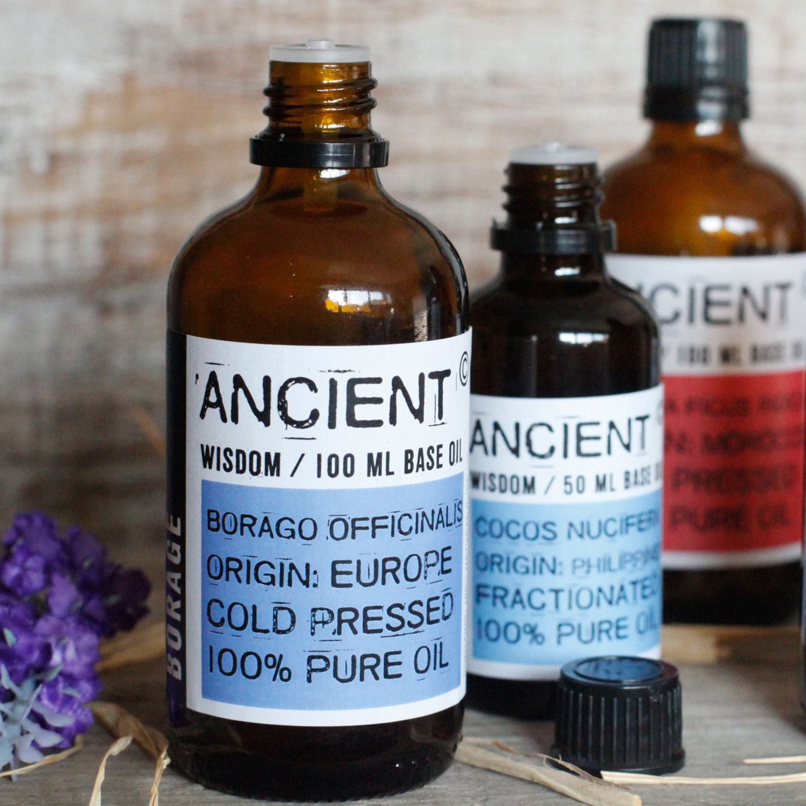 Apricot Kernel Base Oil – 50ML bottle of cold pressed base oil on wooden surface with other amber oil bottles