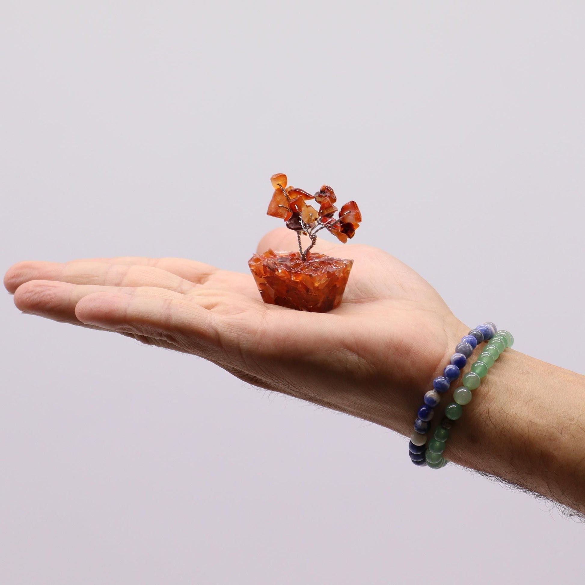 Assorted Mini Gemstone Trees – Orgonite Base Set of 12, mini gemstone tree with orange chips on orgonite base displayed on hand