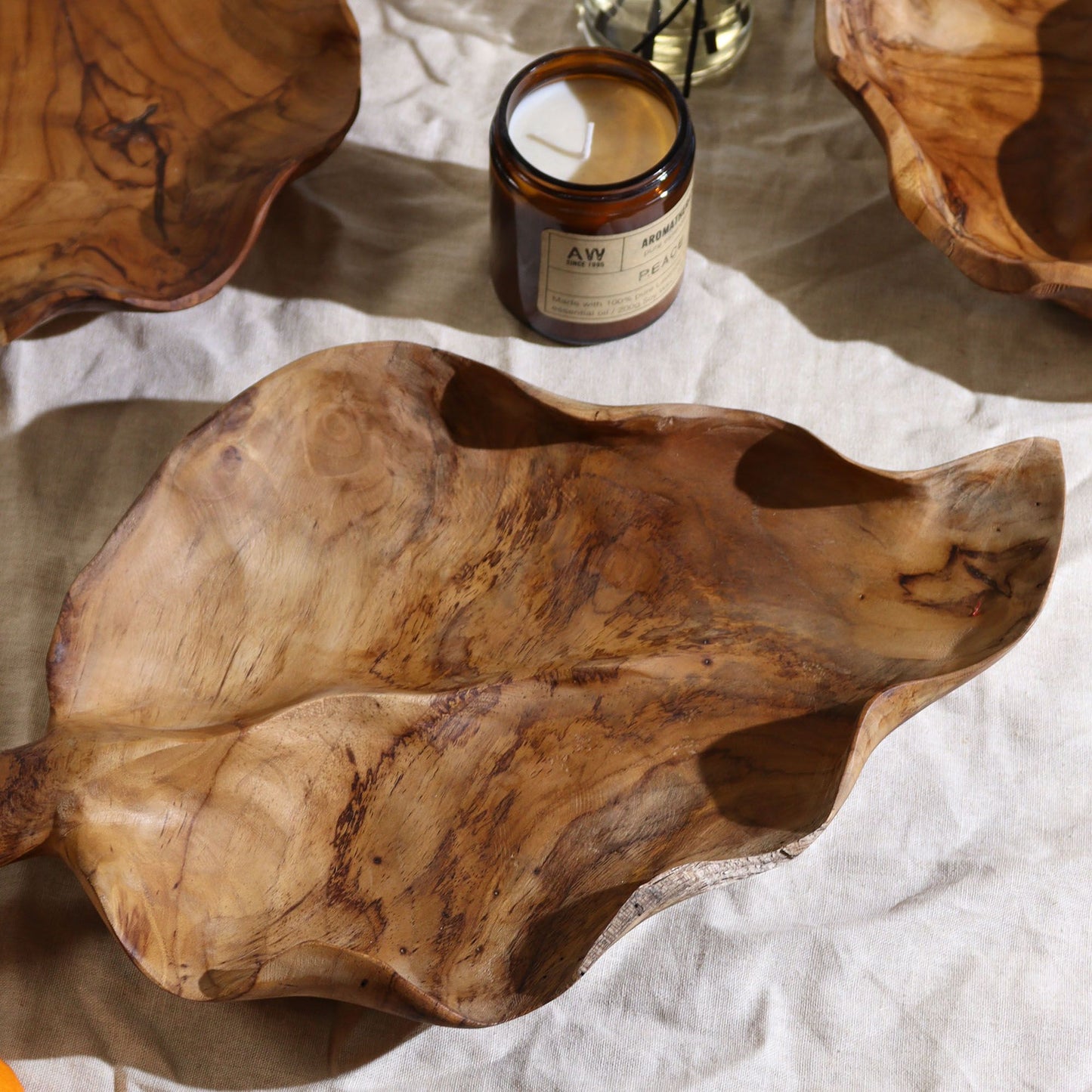 Handcrafted leaf-shaped teak fruit bowl showcasing natural grain and polish