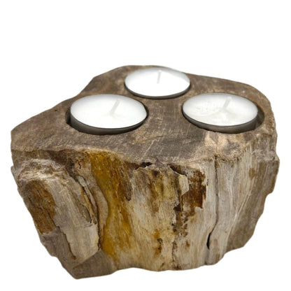 Portavelas triple de madera petrificada en piedra natural con tres huecos para velas, textura orgánica y vetas únicas