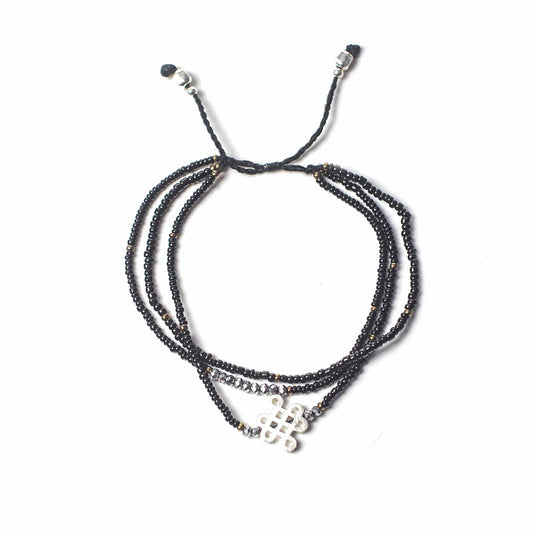 Black endless knot temple string bracelet with metal charm and beads, adjustable unisex spiritual grounding jewelry
