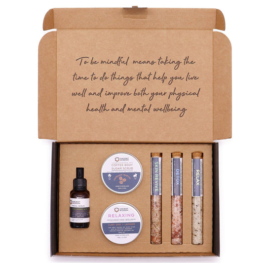Mindful Moments self care kit with coffee sugar scrub, body cream, three bath salts vials, and hyaluronic acid serum