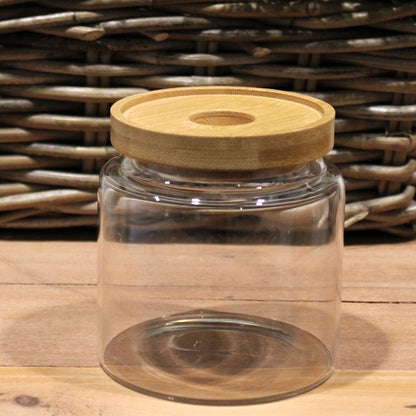 Alt-Tag: Glas-Vorratsglas mit Bambusdeckel – 10 CM, transparentes Borosilikatglas mit Bambusdeckel auf einem Holztisch