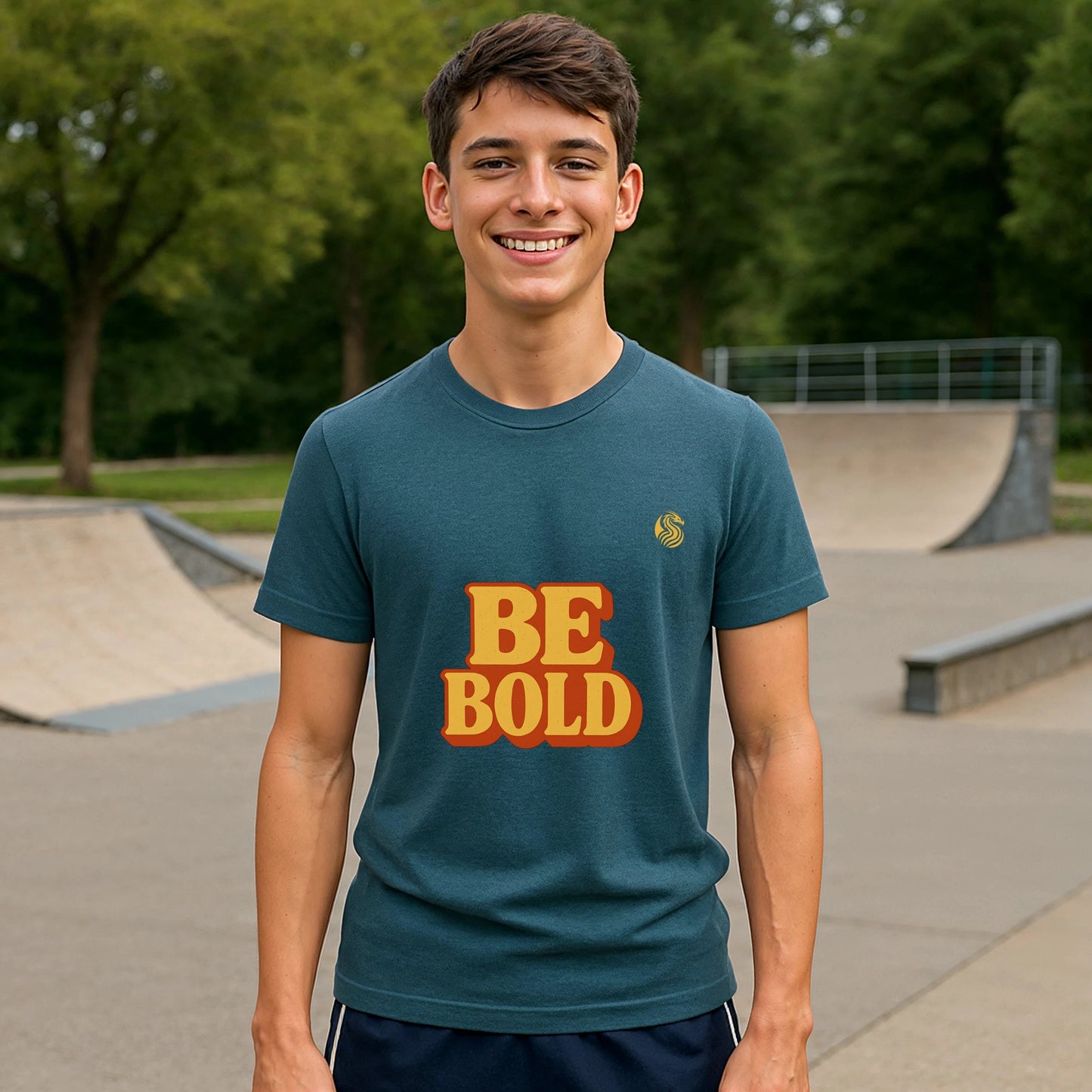 Be Bold Youth 100% Organic Cotton T-Shirt on teen model, teal shirt with BE BOLD graphic at skate park