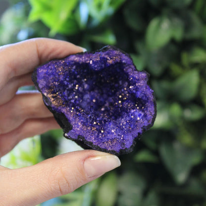 Alt Tag: Black Rock Calcite Geode – Turquoise – 8.5x6 CM hand-held geode with turquoise crystal interior, close-up view