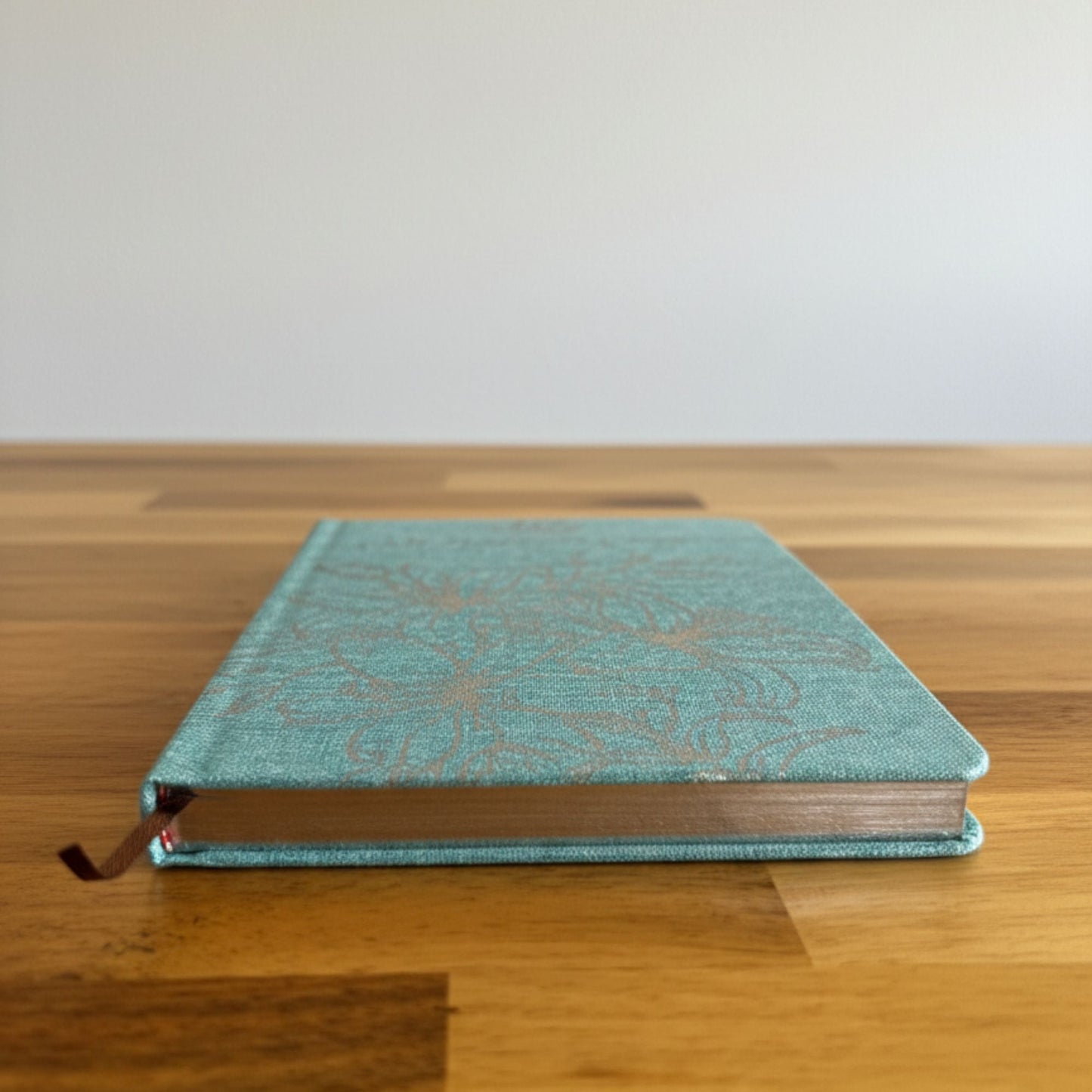 Blue Gratitude Journal with Silver Lining – 120 Pages – I Am Thankful For blue hardcover journal with silver-lined edges on wooden table