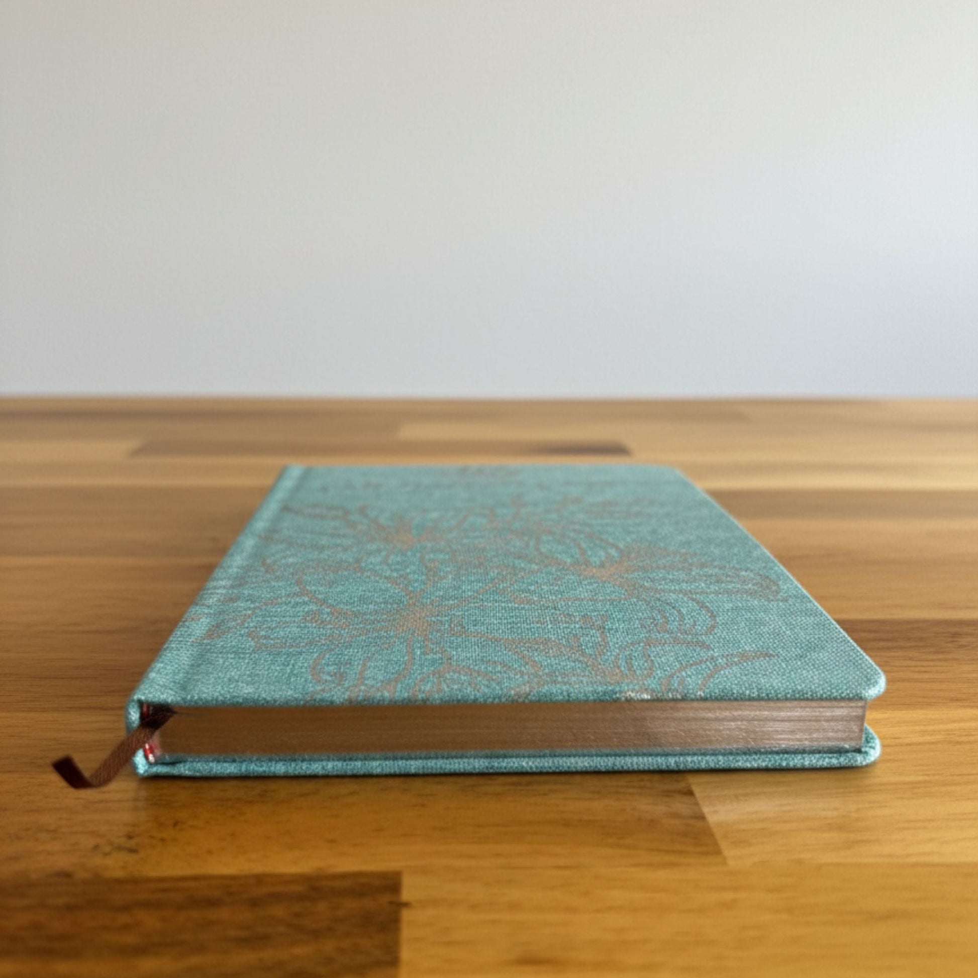 Blue Gratitude Journal with Silver Lining – 120 Pages – I Am Thankful For blue hardcover journal with silver-lined edges on wooden table