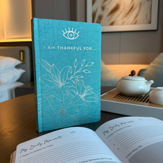 Blå tacksamhetsdagbok med silverkant – 120 sidor – I Am Thankful For blå dagbok med omslag på skrivbordet, ”I Am Thankful For” på framsidan
