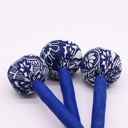Alt Tag: Martillo de masaje de ajenjo azul – herramienta de madera con cabezales cubiertos de tela azul y mangos de madera envueltos sobre fondo blanco