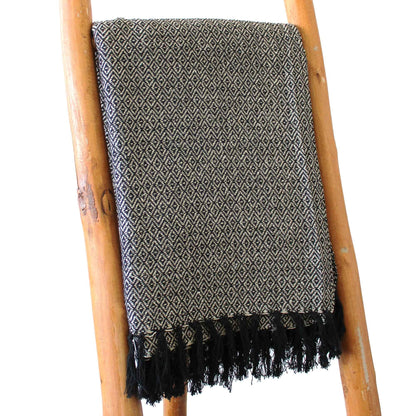 Alt Tag: Boho Comfort Throw – Kolgrått handvävt bomullspläd med bohotextur, fransade kanter, draperad på en trästege