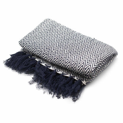 Boho Comfort-pläd – handvävd pläd i bomull med marinblått sicksackmönster och tofsar, vikt mot vit bakgrund