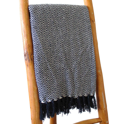 Boho Comfort-pläd – marinblå handvävd bomullspläd med marinblått sicksackmönster och fransar, draperad på en trästege