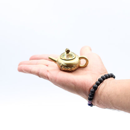Alt Tag: Brass Feng Shui Teapot Spinner – 8x4.5 CM brass teapot spinner in hand, small decorative Feng Shui desk accessory