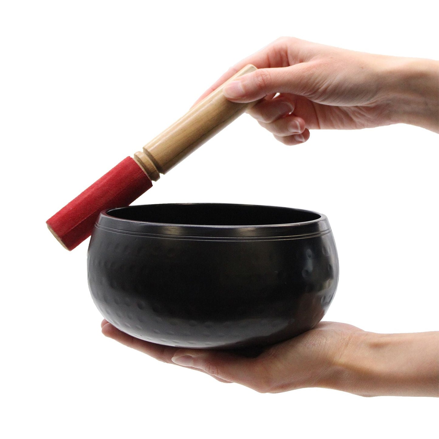 Brass Tibetan Singing Bowl – 18 CM black brass singing bowl held in hands with wooden mallet