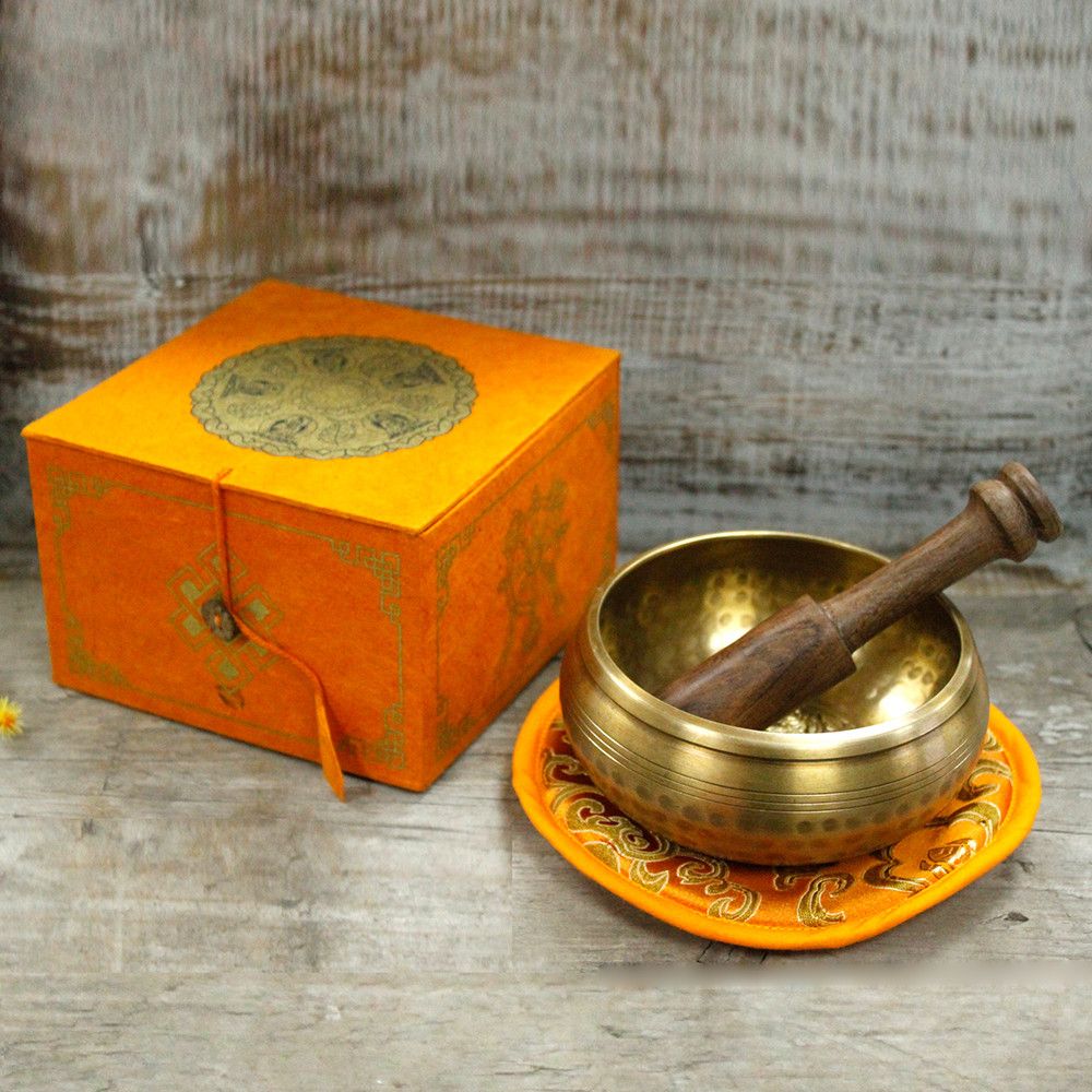 Set med tibetansk klangskål i mässing – 10CM 400G med träklubba, kudde och orange ask på träyta