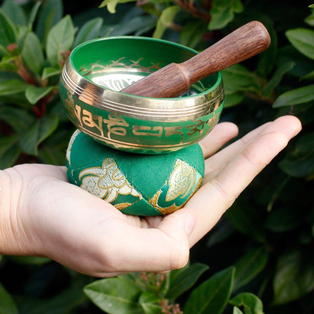 Alt Tag: Brass Tibetan Singing Bowl Set – 6x8 CM brass singing bowl with wooden striker on green cushion held in hand