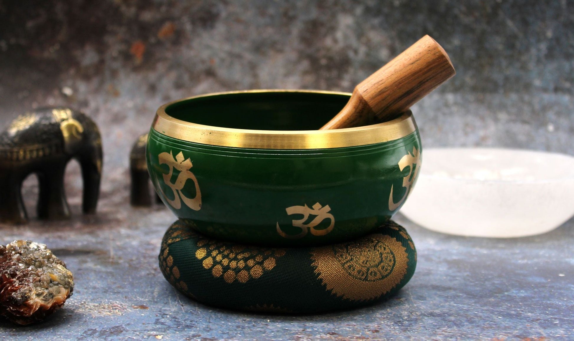 Alt Tag: Brass Tree of Life Singing Bowl Set – Green 14CM with wooden striker on cushion, green brass bowl with Om symbols