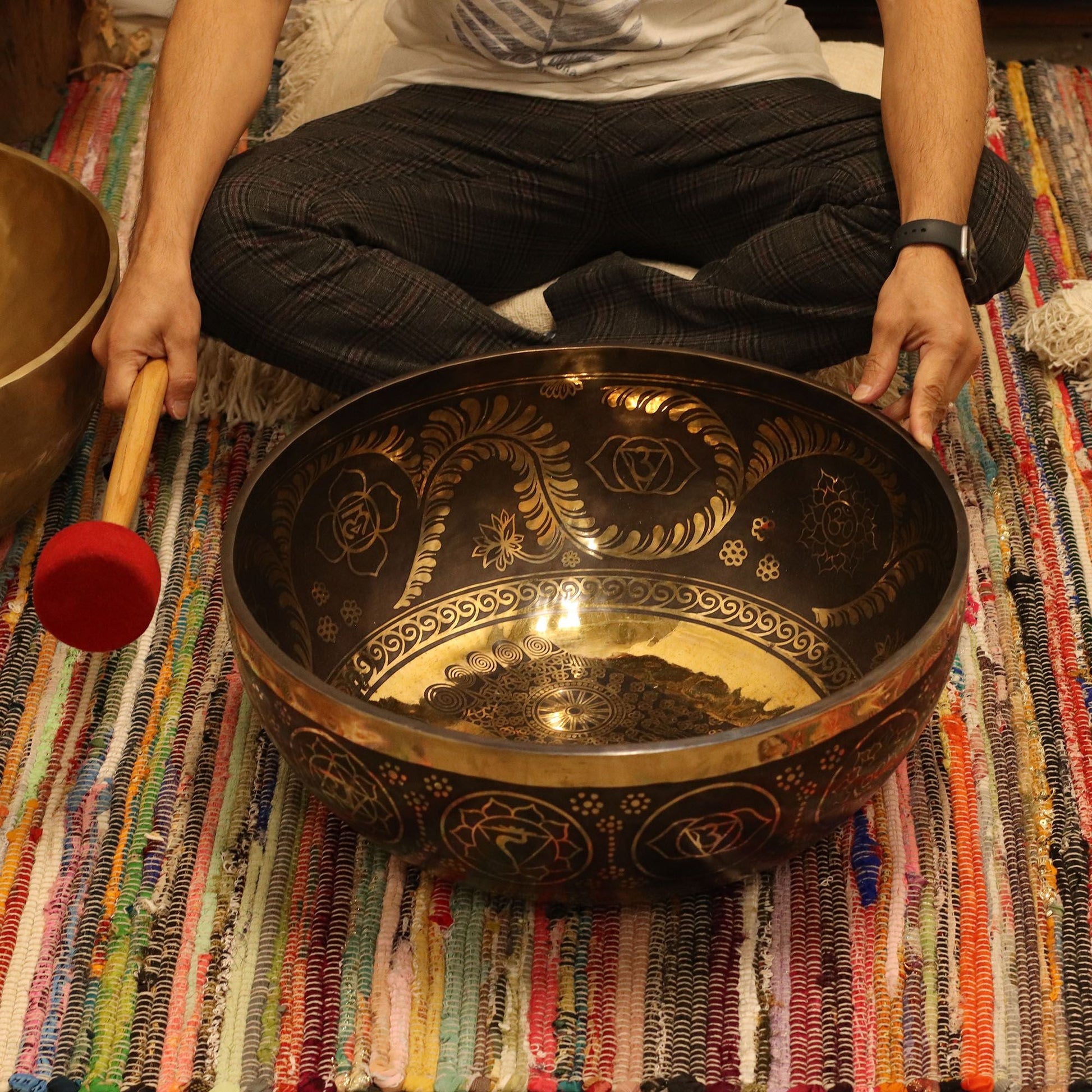 Brass Vibrational Standing Singing Bowl – 50x20CM brass singing bowl with engraved design and mallet on colorful woven rug