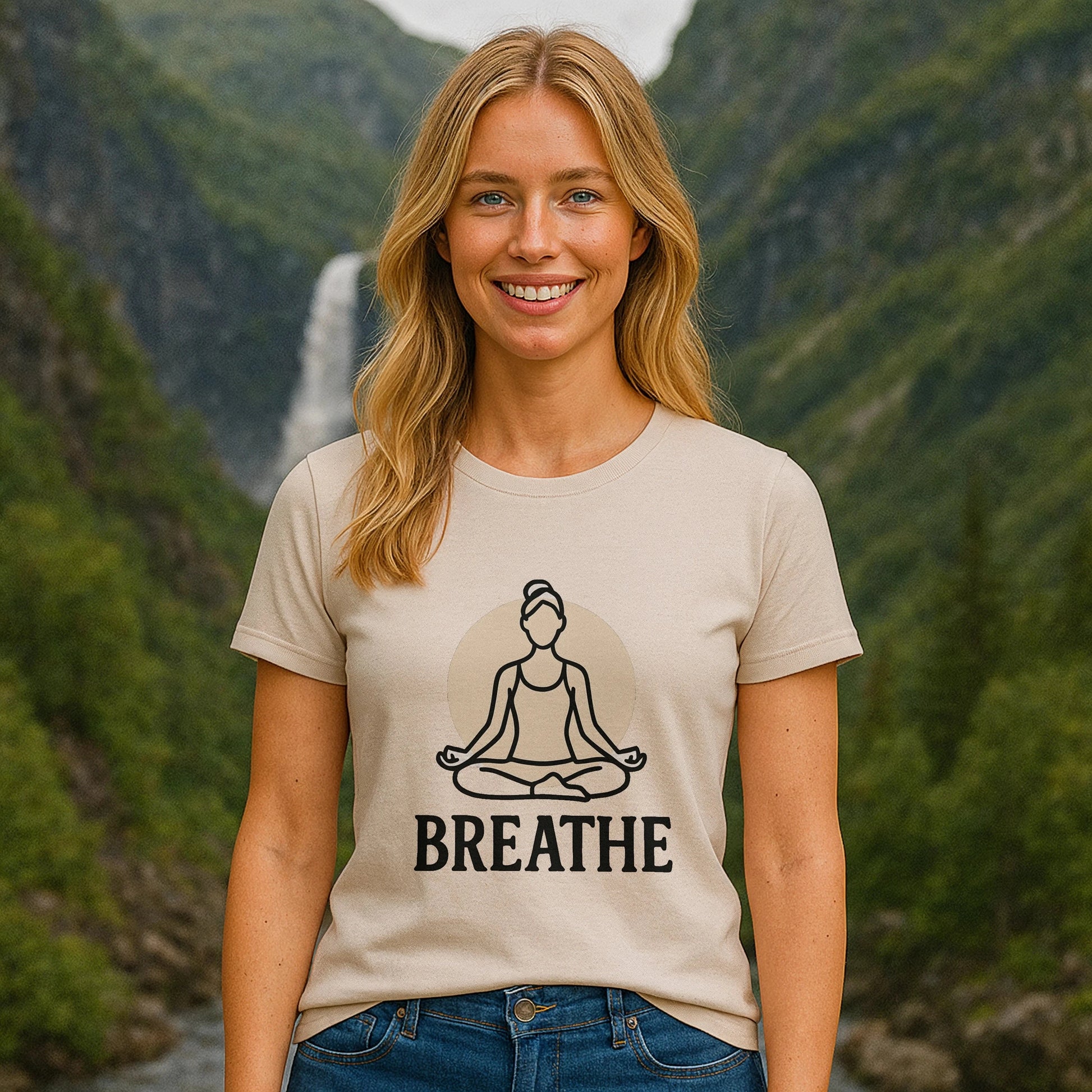 Breathe Yoga Premium Unisex T-Shirt beige con gráfico de meditación y texto BREATHE, modelo al aire libre en valle montañoso