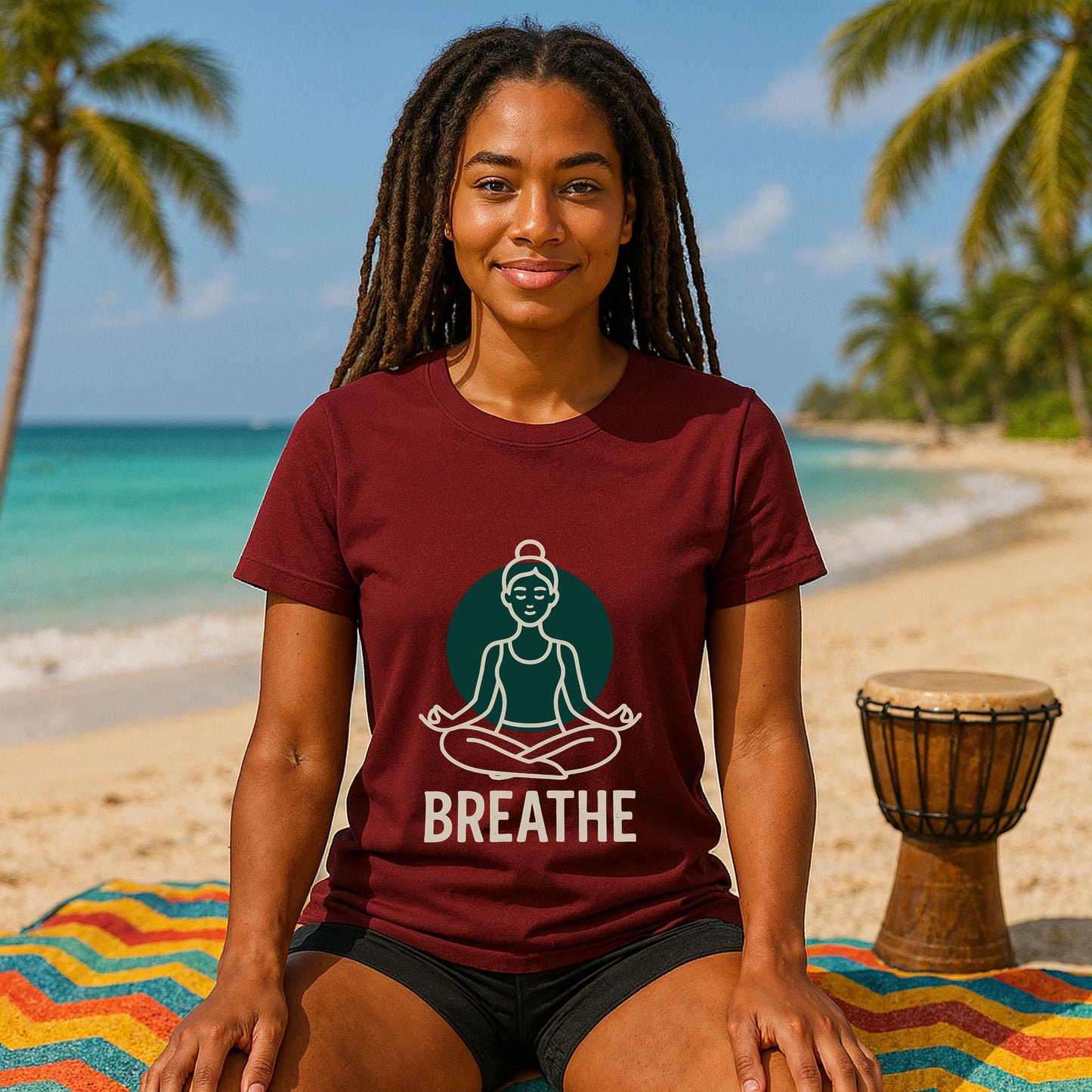 Alt Tag: Breathe Yoga Premium Unisex T-Shirt burgundy with meditating figure and "BREATHE" print, worn by woman seated on beach