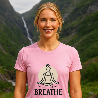 Alt Tag: Mujer con camiseta rosa Breathe Yoga Premium Unisex T-Shirt con diseño "BREATHE" y figura de meditación en paisaje de montaña