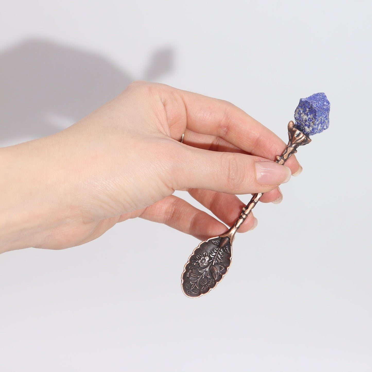 Alt Tag: Bronze Gemstone Witch Spoon Set – 7 Magical Spoons, bronze spoon with blue lapis lazuli gemstone handle held in hand