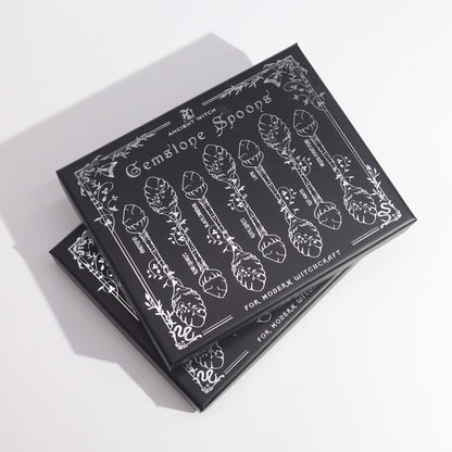 Alt Tag: Bronze Gemstone Witch Spoon Set – 7 Magical Spoons gift box with illustrated spoons and botanical design, black packaging