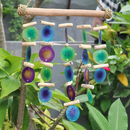 Alt-Tag: Capiz Shell Driftwood Chime – 32x25 CM mit mehrfarbigen Capiz-Scheiben und Treibholzstücken, die im Außenbereich hängen