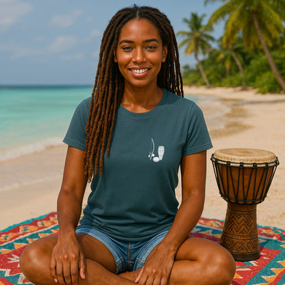 Alt Tag: Capoeira Music Sustainable Unisex Tee worn by person on beach, teal tee with small berimbau and drum graphic
